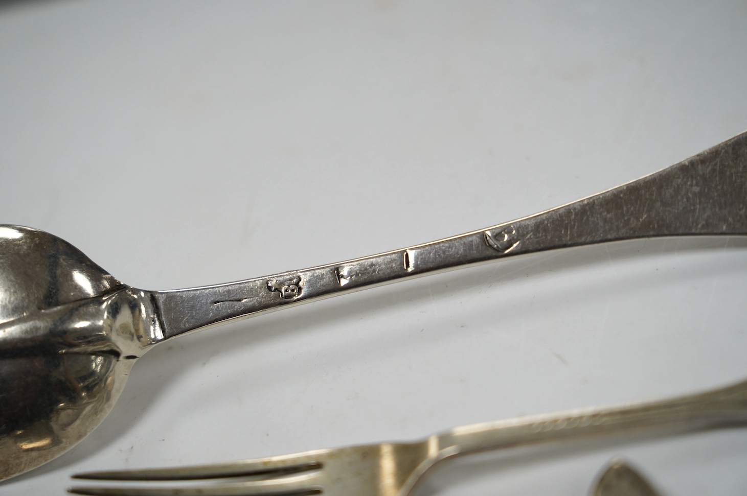 An early 18th century Hanovarian rat-tail pattern table spoon, indistinct marks, 19.6cm and a small quantity of later assorted silver flatware, 21.7oz. Condition - poor to fair